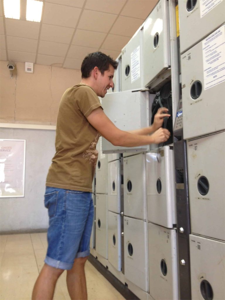 Auston stuffing our backpacks into one small locker to save some money.